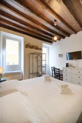 a bedroom with a large white bed and a window at Trident Suite by BuddyRent in Rome