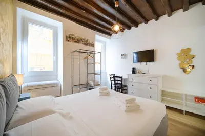 a bedroom with a white bed and a tv at Trident Suite by BuddyRent in Rome