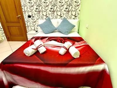 a bed with red and white blankets and pillows at Colosseum Star Guest House in Rome