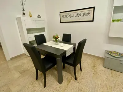 a black dining room table and chairs with flowers on it at Mary's Apartment - House for 4 people - Close to the Vatican in Rome