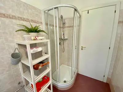 a shower in a bathroom with a white shelf at Mary's Apartment - House for 4 people - Close to the Vatican in Rome