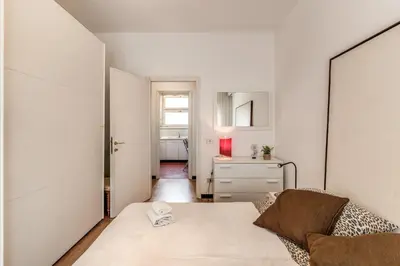 a white living room with a couch and a mirror at Zeus House in Rome