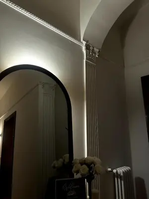a hallway with a mirror and a vase of flowers at The Apartment 56 in Rome