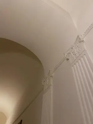 a room with a white ceiling and a pillar at The Apartment 56 in Rome
