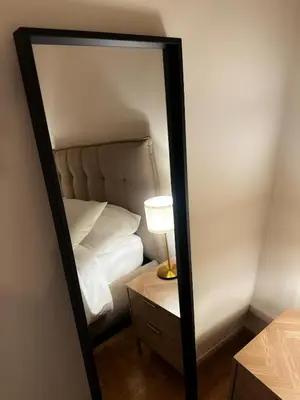a mirror in a room with a bed and a lamp at The Apartment 56 in Rome