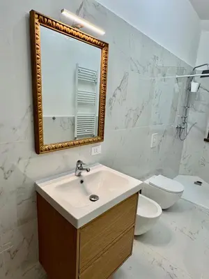 a bathroom with a sink and a toilet and a mirror at Elegant Home in Rome Appio, Wi-Fi, Subway in Rome