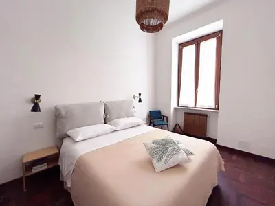 a white bedroom with a large bed with a window at Le Stanze di Margot con Parcheggio Privato in Rome