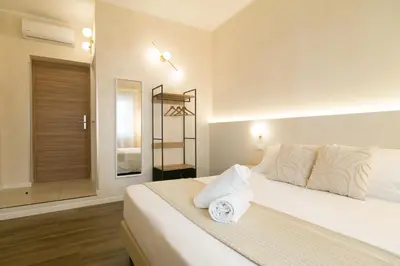 a bedroom with a bed with white sheets and a window at Lilla Eco House - Vaticano in Rome