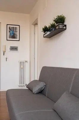 a couch in a living room with plants on the wall at Domus Merulana 209 Colosseum Apt in Rome