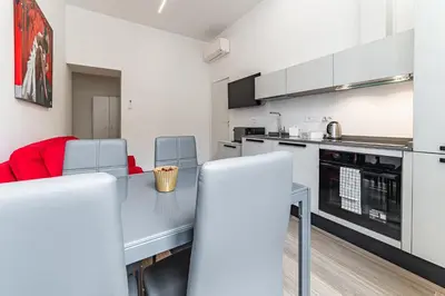 a kitchen and dining room with a table and chairs at Vatican Suites Apartment - Vatican City in Rome