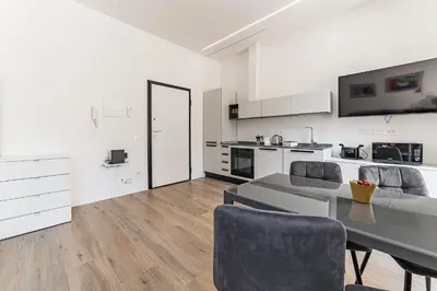 a large white kitchen with a table and chairs at Vatican Suites Apartment - Vatican City in Rome