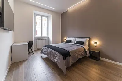 a bedroom with a bed and a desk and a window at Vatican Suites Apartment - Vatican City in Rome