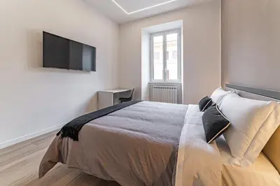 a bedroom with a bed and a flat screen tv at Vatican Suites Apartment - Vatican City in Rome