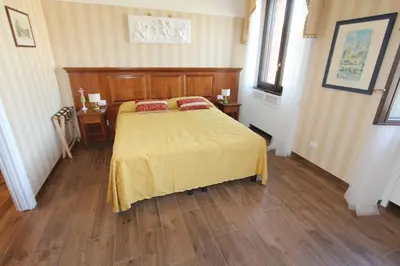 a bedroom with a bed and a wooden floor at Area Sacra Relais in Rome