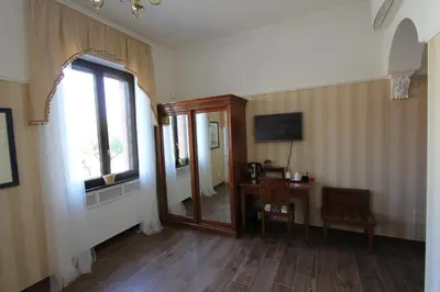 a room with a mirror and a table and a window at Area Sacra Relais in Rome
