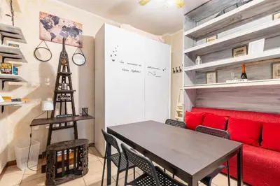 a dining room with a table and a red couch at Margot Appia's dream in Rome
