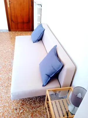 a white couch with two blue pillows on it at Domus Remo Room #3 in Rome