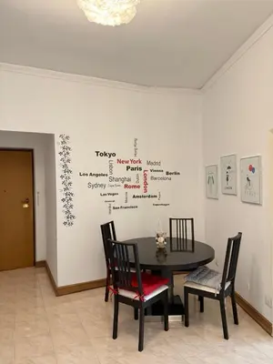a table and chairs in a room with a wall at Vatican Family House Metro A - Rome Collection in Rome