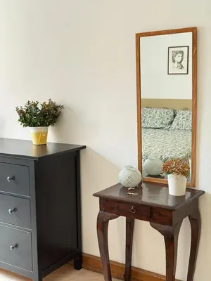 a dresser with a mirror and a wooden table with a dresser at Vatican Family House Metro A - Rome Collection in Rome