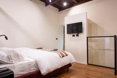 a bedroom with a bed and a tv on the wall at Maison Ametie in Rome