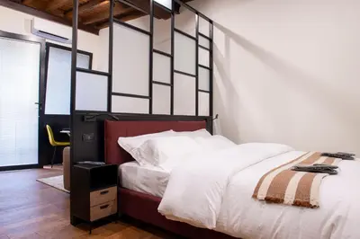 a bedroom with a large bed with white sheets at Maison Ametie in Rome