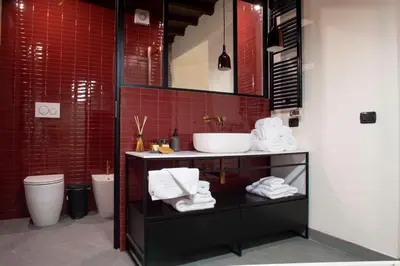 a bathroom with a sink and a toilet and red tiles at Maison Ametie in Rome