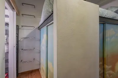 a walk in closet with glass doors and shelves at Loft bohémien a Trastevere in Rome