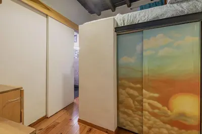 a sliding glass door with a painting of clouds at Loft bohémien a Trastevere in Rome