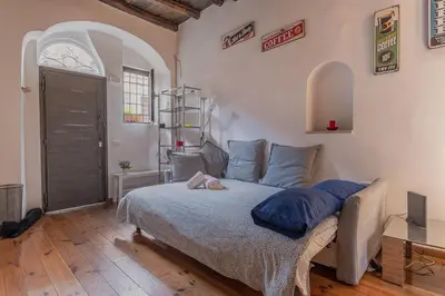 a bedroom with a large bed with blue pillows at Loft bohémien a Trastevere in Rome