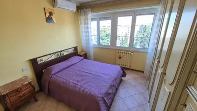 a bedroom with a purple bed and a window at Panorama San Paolo in Rome