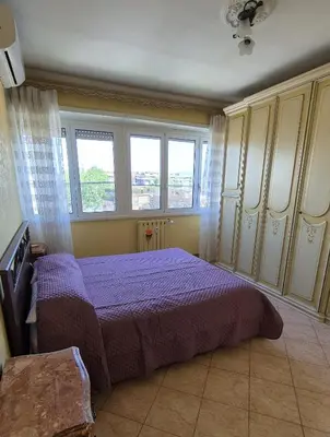 a bedroom with a purple bed and two windows at Panorama San Paolo in Rome