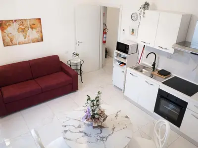 a living room with a red couch and a table at De Camillis Apartments in St Peter in Rome