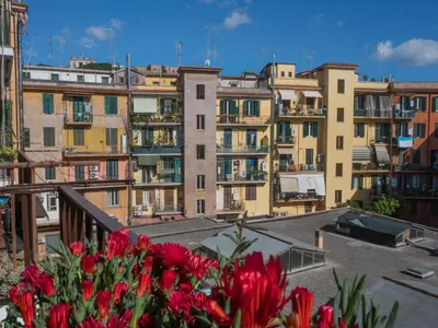 a group of buildings with red flowers in the foreground at De Camillis Apartments in St Peter in Rome