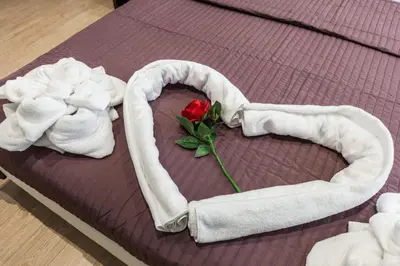 a heart shaped bed with a rose and towels at Stardust Rome Guest House in Rome