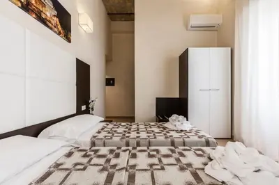 a bedroom with a bed and a white cabinet at Stardust Rome Guest House in Rome