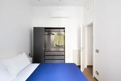 a bedroom with a blue bed and a closet at Casa Simone - The Italian Stay Collection in Rome