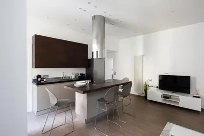 a kitchen with a kitchen island with chairs and a tv at Casa Simone - The Italian Stay Collection in Rome