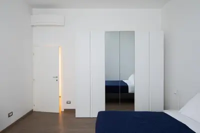 a bedroom with white walls and a bed and a mirror at Casa Simone - The Italian Stay Collection in Rome