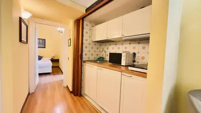 a kitchen with white cabinets and a microwave at Historic apartment by the Pantheon in Rome