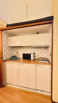 a kitchen with white cabinets and a microwave at Historic apartment by the Pantheon in Rome