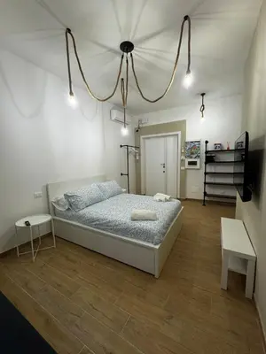 a bedroom with a bed and a chandelier at Olimpia Love Apartament in Rome