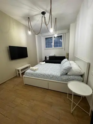 a bedroom with a bed and a table and a tv at Olimpia Love Apartament in Rome
