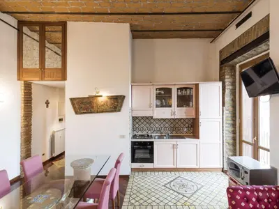 a kitchen with a glass table and pink chairs at Apartment Lucilla Home by Interhome in Rome