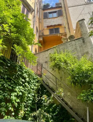 an entrance to a building with a gate and a column at House-Museum Palazzo Podocataro in Rome