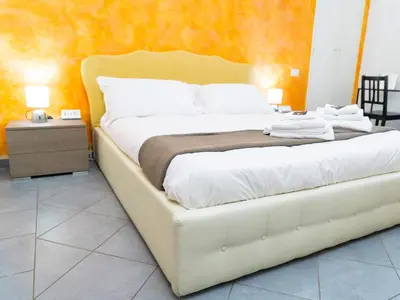 a bedroom with a white bed with an orange wall at Salotto Piramide in Rome