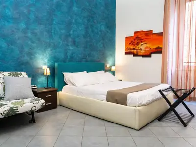 a bedroom with a bed and a chair in it at Salotto Piramide in Rome
