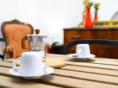 a coffee maker and two cups on a wooden table at Salotto Piramide in Rome