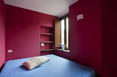 a bedroom with red walls and a bed with a pillow at Laurina F2 roof terrace - LOCAPPART in Rome