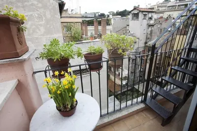 a balcony with a table and flowers on a railing at Laurina F2 roof terrace - LOCAPPART in Rome