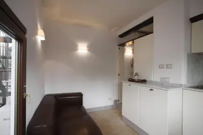 a living room with a couch and a kitchen at Laurina F2 roof terrace - LOCAPPART in Rome